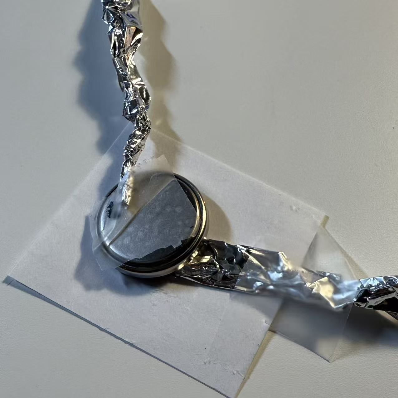 Connect strips of tinfoil (or wire) to the positive and negative terminals being careful that they don't touch.